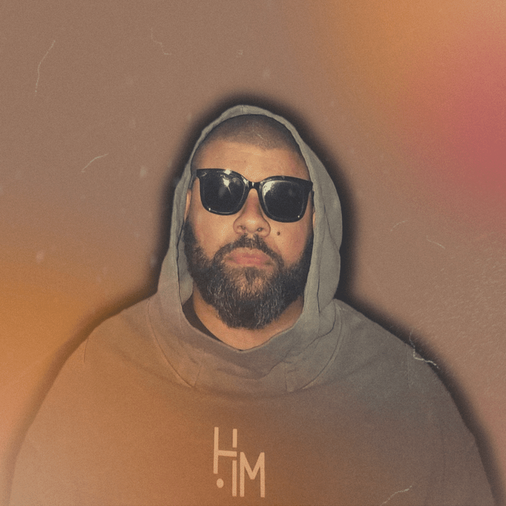 Stylized portrait of Andre Ramone wearing a gray hoodie with the hood up and sunglasses, looking directly at the camera under harsh flash lighting