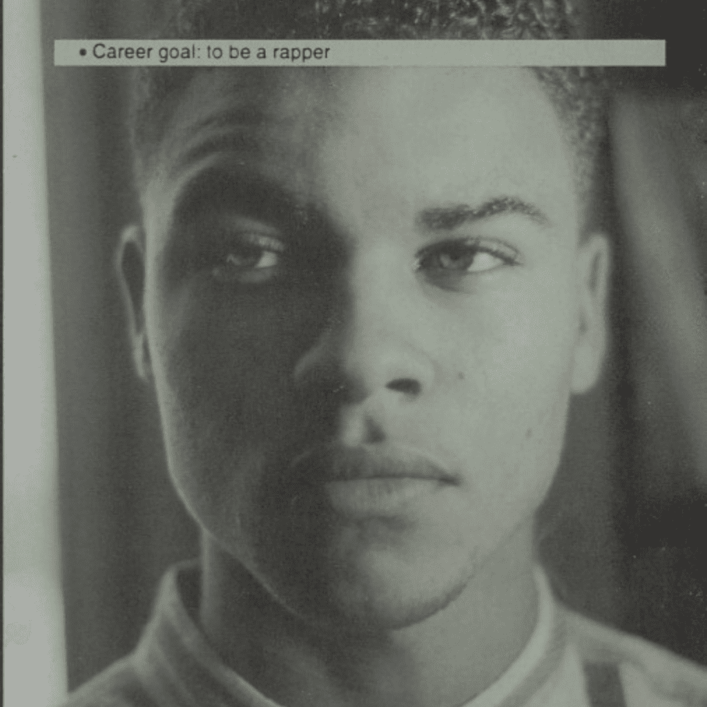 Black-and-white yearbook portrait of Andre Ramone with half of his face in shadow, accompanied by text reading “career goal: rapper”